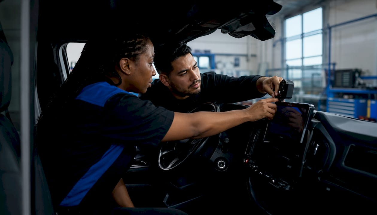 Hands installing AI fleet devices in truck cab