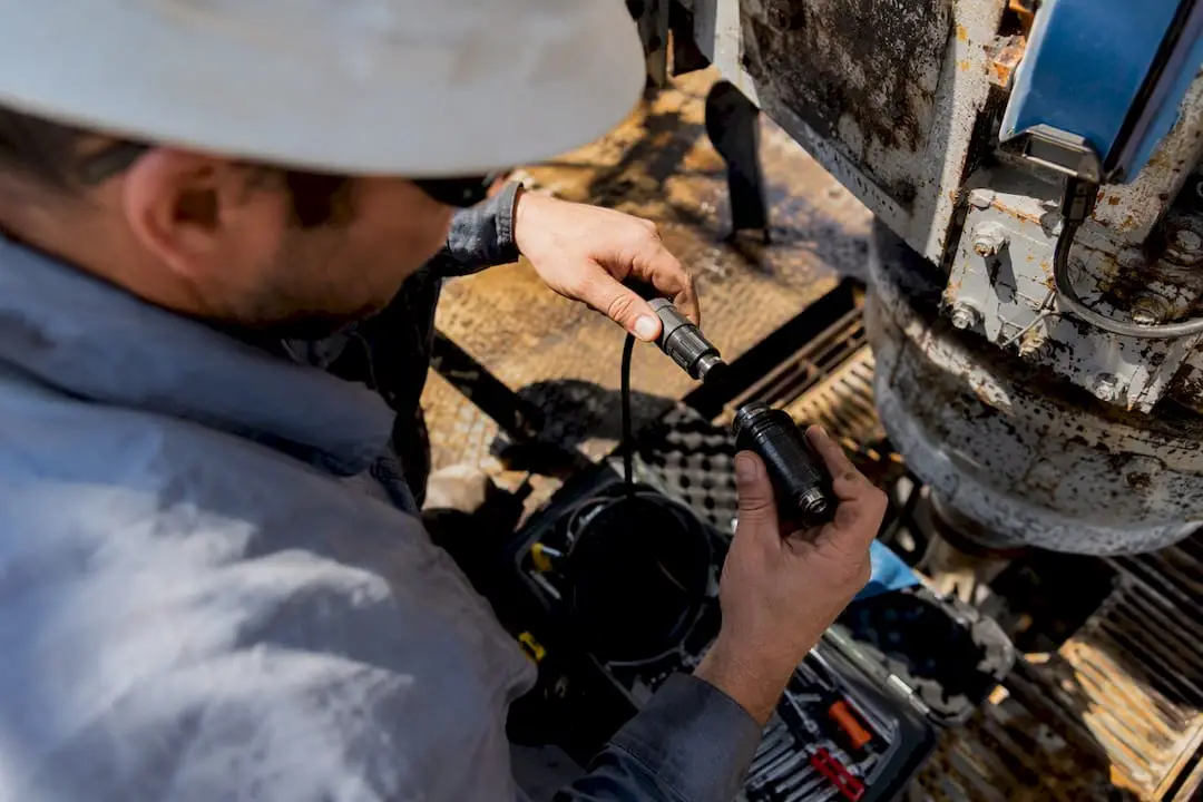 Technician installing sensor on oil rig equipment