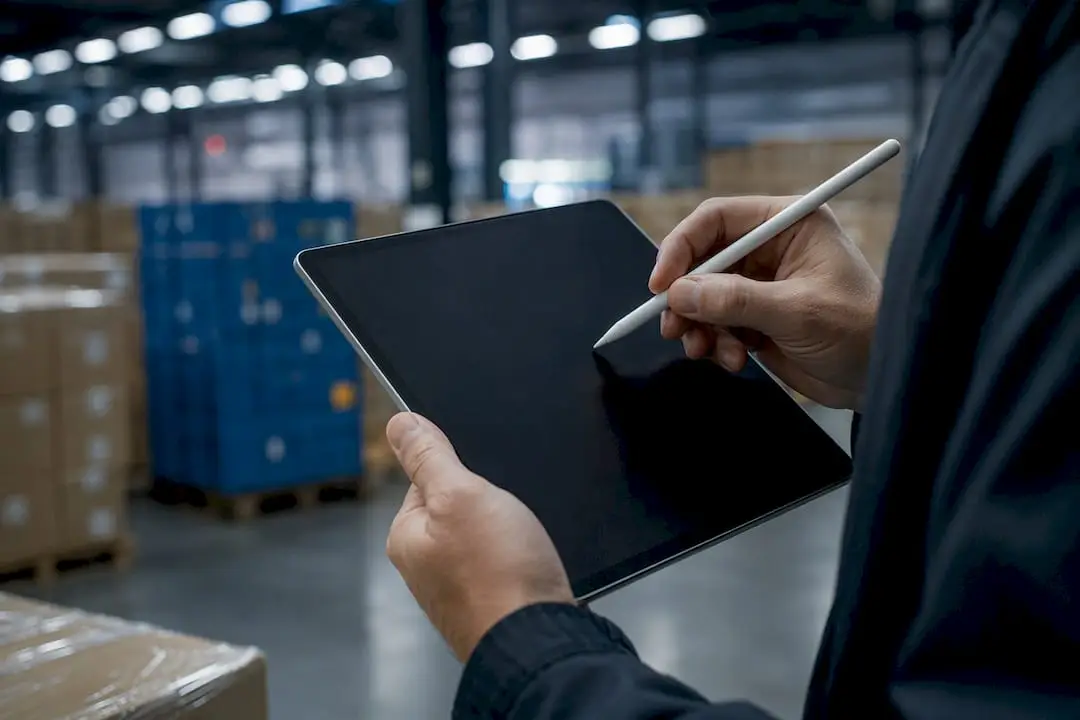 Hands drawing logistics workflow on tablet