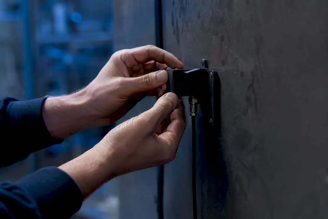 Hands installing sensor device on control panel