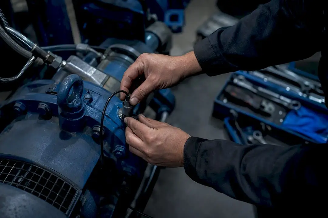 Hands installing vibration sensor on pump