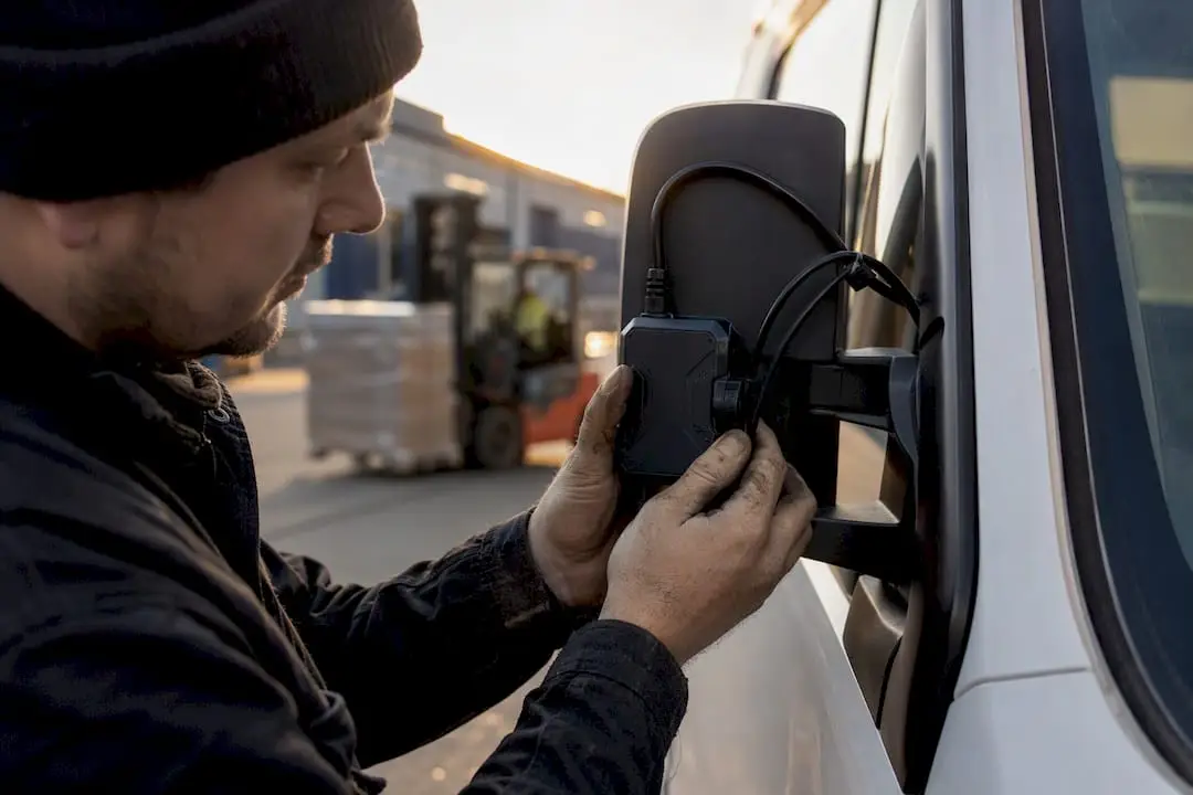 Technician installing mobile GPS tracking device